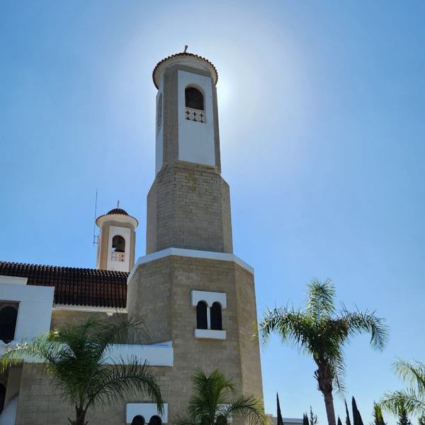 Sunlit stone church with a bell tower